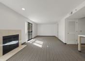 Thumbnail 68 of 92 - an empty living room with a fireplace and a door to a hallway at AVIA Lofts on Parkway Apartments, Vancouver, WA, 98662