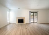 Thumbnail 62 of 108 - an empty living room with a fireplace and sliding glass doors