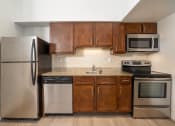 Thumbnail 58 of 108 - a kitchen with wooden cabinets and stainless steel appliances