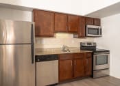 Thumbnail 57 of 108 - a kitchen with wooden cabinets and stainless steel appliances