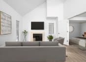 Thumbnail 49 of 108 - a living room with a gray couch and a fireplace