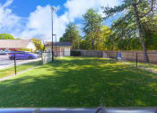 Thumbnail 10 of 108 - a fenced in backyard with a lawn and a fence