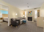 Thumbnail 100 of 108 - a living room with a couch and a fireplace in a hotel room