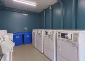 Thumbnail 34 of 108 - a row of washers and dryers in a laundry room