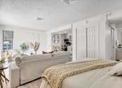 Thumbnail 10 of 61 - a bedroom with a bed and a living room with a couch at AVIA Lofts on Liberty Ridge, Florida, 32256