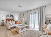 Thumbnail 6 of 61 - a living room with a couch and a sliding glass door to a bedroom at AVIA Lofts on Liberty Ridge, Florida