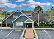 Thumbnail 16 of 61 - a blue house with a parking lot and palm trees at AVIA Lofts on Liberty Ridge, Florida