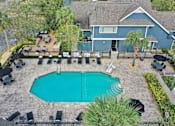 Thumbnail 36 of 61 - an aerial view of a swimming pool with a house in the background at AVIA Lofts on Liberty Ridge, Jacksonville, FL