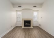 Thumbnail 78 of 108 - an empty living room with a fireplace and wooden floors