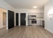 Thumbnail 75 of 108 - an empty living room and kitchen with black doors and stainless steel appliances