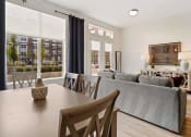 Thumbnail 47 of 83 - a living room with a couch and a table with chairs  at 200 City View, Utah