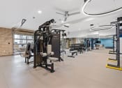 Thumbnail 36 of 84 - a gym with weights and cardio equipment in a building with brick walls at The Revival, Salt Lake City, 84101