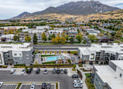Thumbnail 18 of 136 - an aerial view of an apartment complex with a pool and parking lot at The Flats at Riverwoods, Provo, Utah