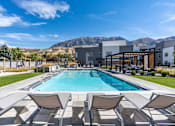 Thumbnail 95 of 136 - a swimming pool with chairs and a building in the background at The Flats at Riverwoods, Provo, UT, 84604