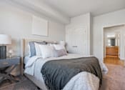 Thumbnail 114 of 136 - a bedroom with a large bed and a door to a bathroom at The Flats at Riverwoods, Provo, Utah