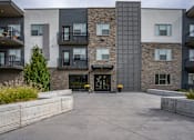 Thumbnail 12 of 136 - an empty courtyard in front of an apartment building at The Flats at Riverwoods, Provo, 84604