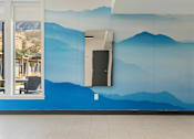 Thumbnail 77 of 136 - a blue wall with mountains painted on it and a door at The Flats at Riverwoods, Provo, UT