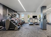 Thumbnail 81 of 136 - a gym with treadmills and other exercise equipment in a room with a tv at The Flats at Riverwoods, Provo, UT, 84604