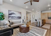 Thumbnail 112 of 136 - an open living room with a kitchen and a ceiling fan at The Flats at Riverwoods, Provo