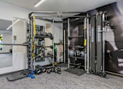 Thumbnail 92 of 136 - a home gym with weights and equipment on the floor and a wall with a mural at The Flats at Riverwoods, Provo, 84604