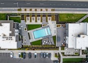 Thumbnail 15 of 136 - an aerial view of a mansion with a large swimming pool in the center of it at The Flats at Riverwoods, Provo, Utah