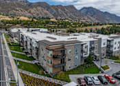 Thumbnail 14 of 136 - an aerial view of an apartment complex with mountains in the background at The Flats at Riverwoods, Provo, Utah