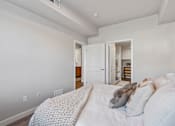 Thumbnail 118 of 136 - a bedroom with a large bed and a door to a bathroom at The Flats at Riverwoods, Provo