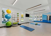 Thumbnail 79 of 136 - a workout room with yoga mats and a colorful ball and a large window at The Flats at Riverwoods, Provo, UT
