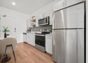 Thumbnail 65 of 126 - an apartment kitchen with stainless steel appliances and a table and chairs  at SevenO2 Main Apartments, Salt Lake City, UT