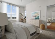 Thumbnail 75 of 144 - A bedroom with a large bed, a painting on the wall, and a wooden floor.