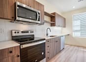 Thumbnail 85 of 144 - A modern kitchen with a stove, microwave, and sink.