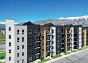 Thumbnail 48 of 144 - A row of modern apartment buildings with a mountain range in the background.