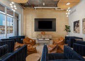 Thumbnail 57 of 131 - a living room with couches and chairs and a television on the wall at Paperbox Lofts, Salt Lake City, Utah