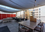 Thumbnail 112 of 131 - a large patio with a table and chairs under a canopy at Paperbox Lofts, Salt Lake City, UT, 84101
