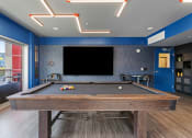 Thumbnail 52 of 131 - a pool table in a clubhouse with a tv on the wall at Paperbox Lofts, Salt Lake City, Utah