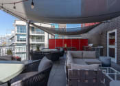 Thumbnail 118 of 131 - a patio with couches and tables and a red wall at Paperbox Lofts, Salt Lake City, UT, 84101