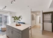 Thumbnail 17 of 131 - a kitchen with an island and a living room with a refrigerator at Paperbox Lofts, Salt Lake City, UT