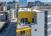 Thumbnail 122 of 131 - a building with a yellow facade and a city in the background at Paperbox Lofts, Salt Lake City, Utah