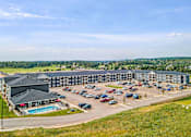 Thumbnail 35 of 74 - a large building with a pool and parking lot at Red Rock Apartments, Rapid City