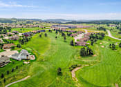 Thumbnail 36 of 74 - arial view of a golf course with houses in the background at Red Rock Apartments, South Dakota