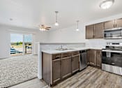 Thumbnail 12 of 74 - a kitchen with wooden cabinets and stainless steel appliances at Red Rock Apartments, Rapid City