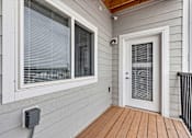 Thumbnail 67 of 74 - a front porch with a door and a window with venetian blinds at Red Rock Apartments, Rapid City, South Dakota