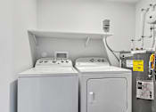 Thumbnail 25 of 74 - Two white washing machines in a laundry room.