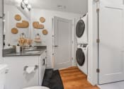Thumbnail 84 of 84 - a small laundry room with a washer and dryer and a sink at The Revival, Utah, 84101
