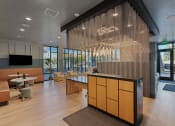 Thumbnail 110 of 126 - a lobby with a reception desk and chairs and a large glass wall with the name at SevenO2 Main Apartments, Salt Lake City, 84101