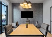 Thumbnail 117 of 126 - a conference room with a table and chairs and a television on the wall at SevenO2 Main Apartments, Salt Lake City