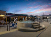 Thumbnail 86 of 126 - a hot tub on the rooftop of a building with a sunset in the background at SevenO2 Main Apartments, Salt Lake City, Utah
