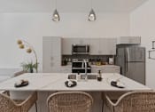 Thumbnail 102 of 126 - an open kitchen with a large island with a white counter top at SevenO2 Main Apartments, Salt Lake City