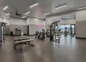 Thumbnail 100 of 126 - a gym with weights and other exercise equipment and a window at SevenO2 Main Apartments, Salt Lake City, UT, 84101
