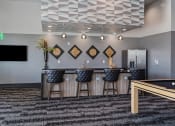 Thumbnail 79 of 126 - a clubhouse with a pool table and a bar with bar stools at SevenO2 Main Apartments, Salt Lake City, Utah
